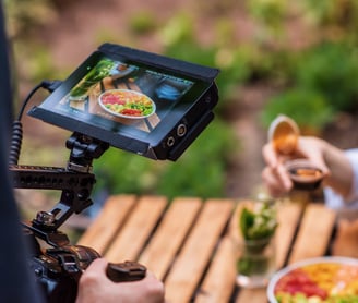 a person holding a camera and taking a video of a person holding a drink