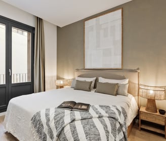 Elegant bedroom with custom artwork and brown and beige colour palette in Barcelona