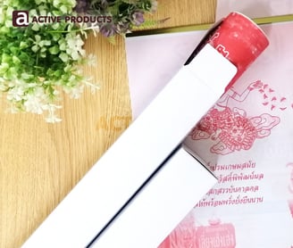 กล่องสีขาวเทาเปิดฝาพร้อมใส่ปฎิทินจีน วางบนกองปฎิทินบนโต๊ะไม้สีอ่อน พร้อมต้นไม้