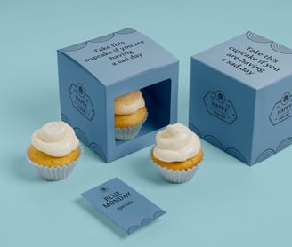 a cupcake in a box with a card