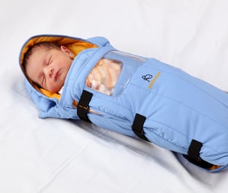 a baby in a portable infant incubator by Embrace Global