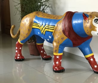 Detalhe da pintura da Onça Maravilha com padrões e cores vibrantes, alusões à Mulher Maravilha.