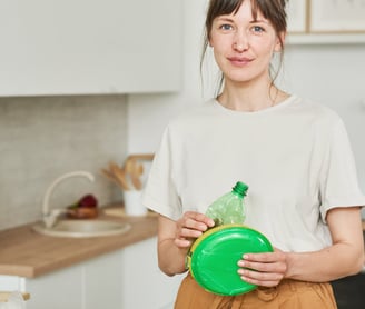 a woman holding a green plastic container with a green lid