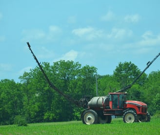 an image of a high clearance sprayer preparing to weed and feed a crop