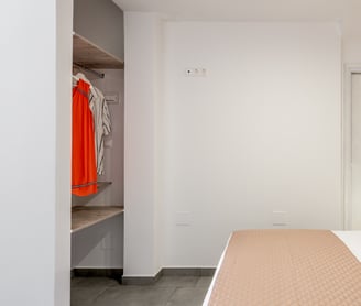 a bedroom with a brick wall and a bed with a bed and a closet