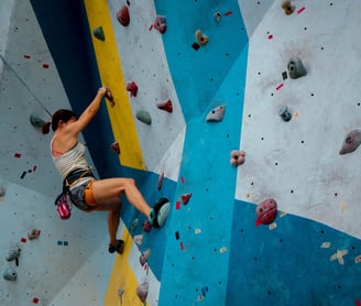 Woman bouldering in a climbing gym; Kobieta wspinająca się w boulderowni