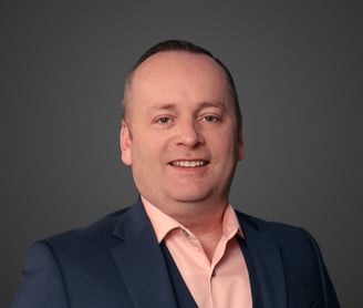 a man in a navy suit and pink shirt