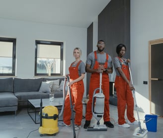 a group of people in orange overalls and overalls are standing in a room
