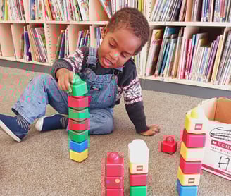 Little boy playing with lego blocks at a library