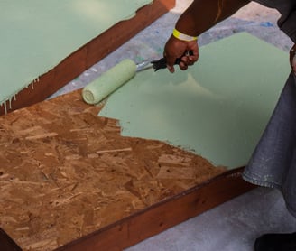 Volunteer painting benches with a roller.