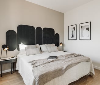 Vibrant bold black wood headboard design in a bedroom with neutral colours and natural materials