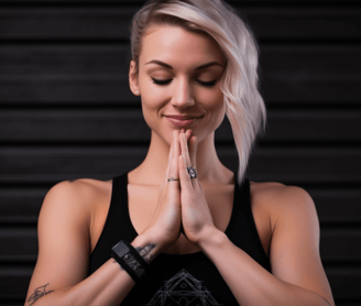 a woman with blonde hair and a black tank top meditating