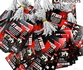กองป้ายแขวนศูนย์บรการดูแลรถ สีดำ แดง เจาะรูพร้อมห้อยเชือกสีขาวมัดเป็นกอง