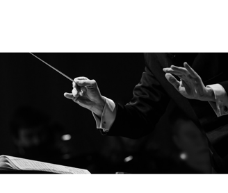 a conductor's hands holding a baton and conducting a concert