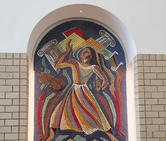 a large mosaic tile window with a large painting of a woman