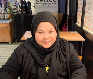 Female in black shirt and hijab in a cafe