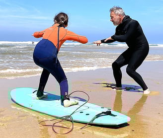 David Marcos, moniteur de surf à Vieux-Boucau, initie une élève au surf sur la plage. 