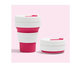 a cup of coffee with a pink cupcake on top of it
