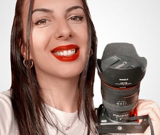 a woman holding a camera and smiling