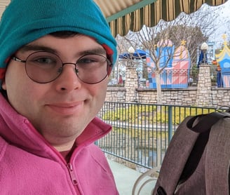 Caddy Sitting at Table Next to His Grey Backpack