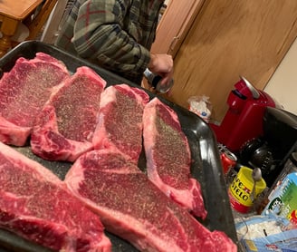 Raw new york strip steaks salt and peppered ready for the grill