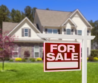 a for sale sign in front of a house