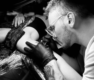 a man is getting a tattoo on his arm in Kaunas