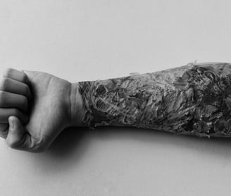 a scabbing tattoo man's arm with a tattoo on it