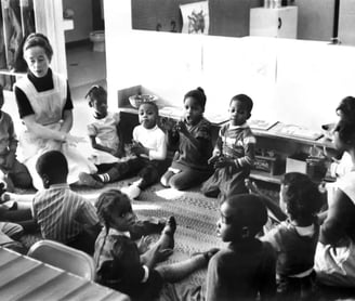 a group of children sitting on the floor in a classroom