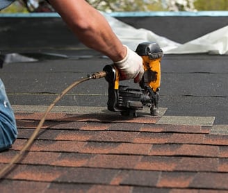 worker installing asphalt roof