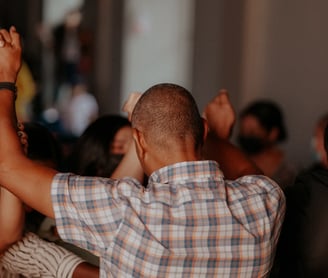 people holding hands up in the air in prayer and praise