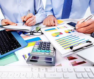 um homem de camisa azul e gravata fazendo cálculos da empresa