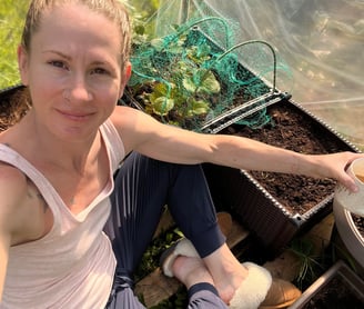 Sitting on the ground inside a green house. 