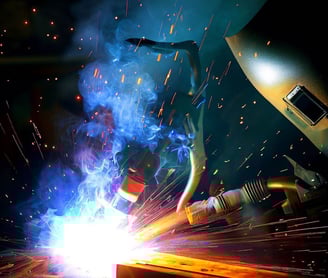 a person welding a piece of metal with a welding headlight