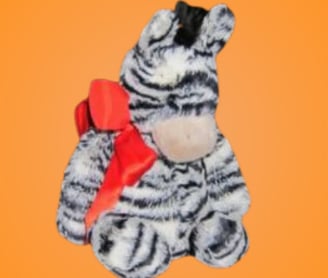 Stuffed zebra wearing a large red bow