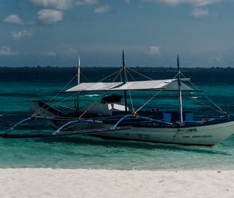 a boat on the beach with a boat in the water