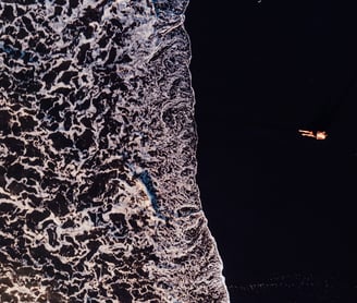 a person standing on a beach with a surfboard