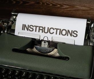 Zielona maszyna do pisania z kartka z napisem INSTRUCTIONS