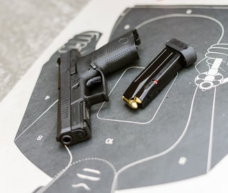 Unloaded firearm and magazine laying on a tactical target