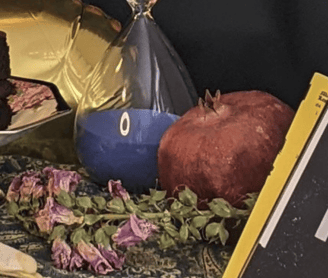 Dried foxglove, a large hourglass with blue sand, and a dried pomegranate