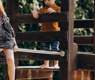enfant jouant sur une cabane en bois