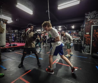 a man in a boxing ring with a punching bag