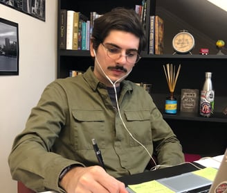 a man in a green shirt is sitting at a desk
