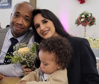 Imagem onde estou com minha família, filho, esposa, em uma festa de casamentos, sentados a mesa.