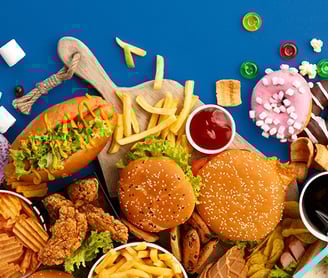 mesa azul com sanduiches, batatas fritas e outras frituras espalhadas
