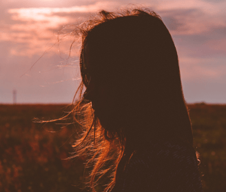 a girl standing in sunset 