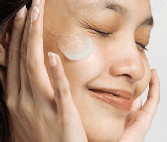 a girl smiling and moisturize is on her face