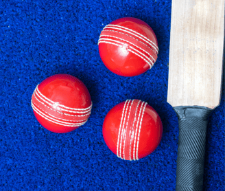 a bat and red colour three balls on blue surface