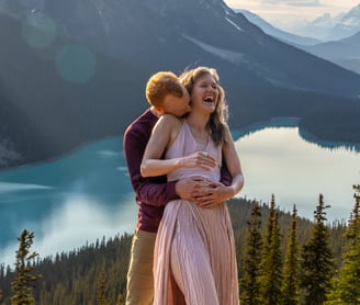 Guy hugging girl from behind at peyto lake