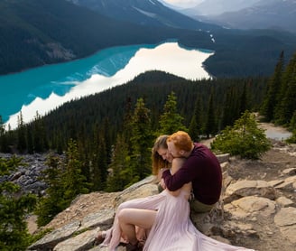 Couple sitting on a rock hugging at peyto lake